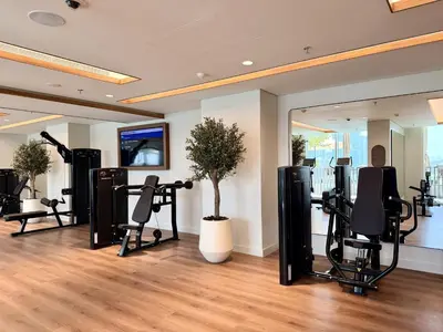 a gym with treadmills and a tree in a room at Palace Beach Residence 2, Emaar Beachfront - Mint Stay in Dubai