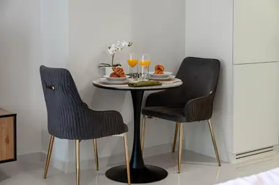 two chairs and a table with a plate of food and drinks at Dubai Business Bay Luxurious Studio with Canal View and access to Lagoon Pool in Dubai