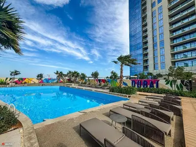 a swimming pool with lounge chairs next to a building at Dubai Business Bay Luxurious Studio with Canal View and access to Lagoon Pool in Dubai