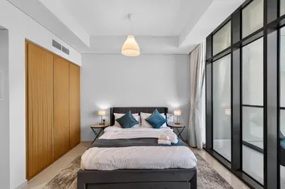 a bedroom with a large bed with blue pillows at Dubai Business Bay Luxurious Studio with Canal View and access to Lagoon Pool in Dubai