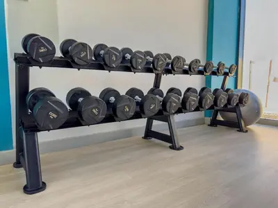 a shelf filled with dumbbells in a gym at Meydan Luxury Stylish 2BR with Pool & City Views in Dubai