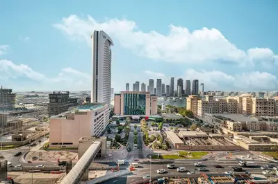 a city skyline with a tall building and traffic at StayMada - Ocean Heights Panoramic Beach Views in Dubai