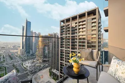 a balcony with a table and a view of a city at StayMada - Peninsula Luxury Apartment with Balcony in Dubai