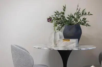 a table with a vase and flowers on it at StayMada - Peninsula Luxury Apartment with Balcony in Dubai