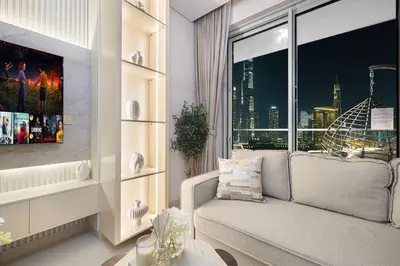 a living room with a couch and a window at VIDA DUBAI MALL - Burj Khalifa Views 2 Bedroom Apartment Opposite Dubai Mall & 5 Minutes Walk To Burj Khalifa and Dubai Fountain by NAMUVE in Dubai