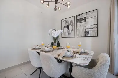 a dining room table with chairs and a vase of flowers at The Burj View Suite by NAMUVE at BLVD Central in Dubai