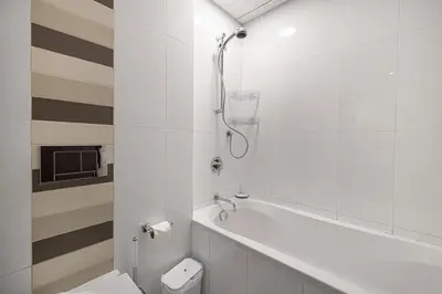 a white bathroom with a toilet and a shower at The Burj View Suite by NAMUVE at BLVD Central in Dubai