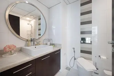 a bathroom with a sink and a mirror at The Burj View Suite by NAMUVE at BLVD Central in Dubai