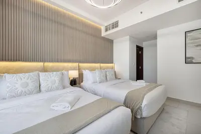 two beds in a hotel room with white at The Imperial Burj View by NAMUVE at 29 Boulevard in Dubai