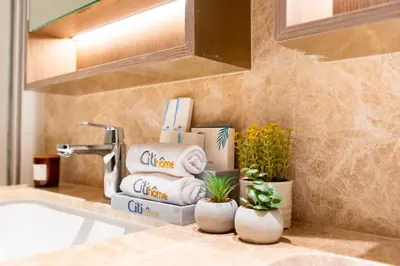 a bathroom with towels and plants on a sink at CitiHome - Elie Saab Luxury 2BR - Sea View in Dubai