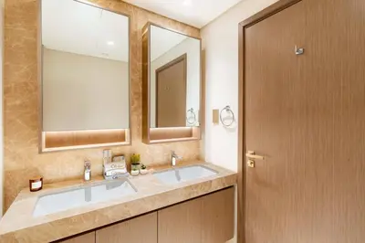 a bathroom with two sinks and a large mirror at CitiHome - Elie Saab Luxury 2BR - Sea View in Dubai