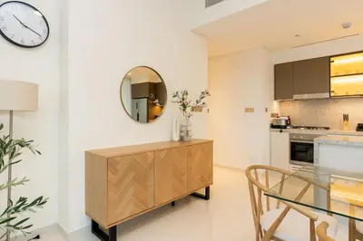 a kitchen with a glass table and a clock on the wall at CitiHome Luxury Stay Panoramic Sea Views 2BR in Dubai