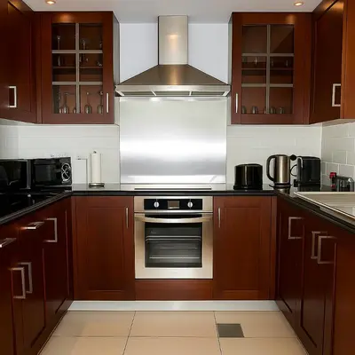 a kitchen with wooden cabinets and a stainless steel oven at Skyline 43 - Penthouse Burj Khalifa View & Pool in Dubai