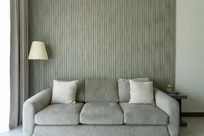a living room with a gray couch and a lamp at 1BR with Burj Khalifa view in Business Bay in Dubai