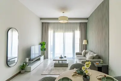 a living room with a couch and a tv at 1BR with Burj Khalifa view in Business Bay in Dubai