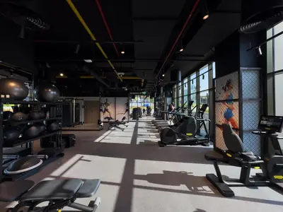 a gym with rows of treadmills and machines at Waterfront 1BR with Canal Views in Peninsula One in Dubai