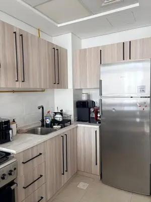 a kitchen with wooden cabinets and a stainless steel refrigerator at Modern apartment Dubai in Dubai