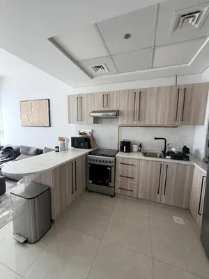 a kitchen with wooden cabinets and a stove top oven at Modern apartment Dubai in Dubai