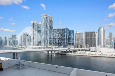a bridge over a river in a city with tall buildings at Bloomfields Canal View 2Br Apt Canal Business in Dubai
