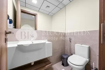 a bathroom with a white sink and a toilet at Bloomfields Canal View 2Br Apt Canal Business in Dubai