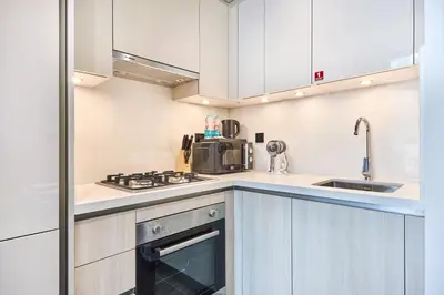 a kitchen with white cabinets and a stove top oven at STAY BY LATINEM Luxury 1BR Holiday Home CC 2913 Near Burj Khalifa in Dubai
