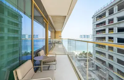 a balcony with a table and chairs in a building at Zapbed House -Elegant 1 BR Apartment Grand Bleu Emaar Beachfront in Dubai