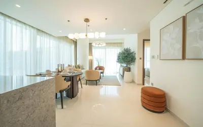 a dining room and living room with a table and chairs at Zapbed House -Elegant 1 BR Apartment Grand Bleu Emaar Beachfront in Dubai