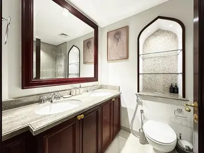 a bathroom with a sink and a toilet and a mirror at Arabian Nights Luxury Garden Suite in Dubai