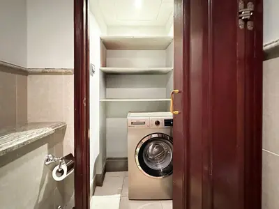 a washer and dryer in a small bathroom at Arabian Nights Luxury Garden Suite in Dubai