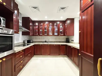 a large kitchen with wooden cabinets and appliances at Arabian Nights Luxury Garden Suite in Dubai