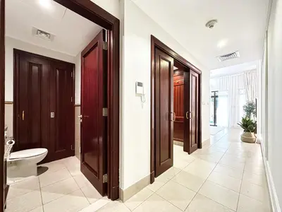 a bathroom with two doors and a toilet in it at Arabian Nights Luxury Garden Suite in Dubai