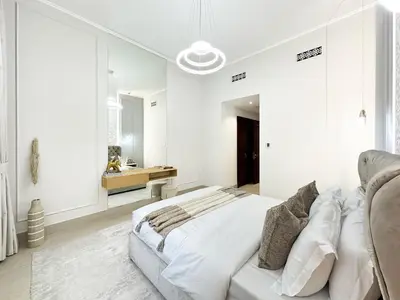 a white bedroom with a bed and a couch at Arabian Nights Luxury Garden Suite in Dubai