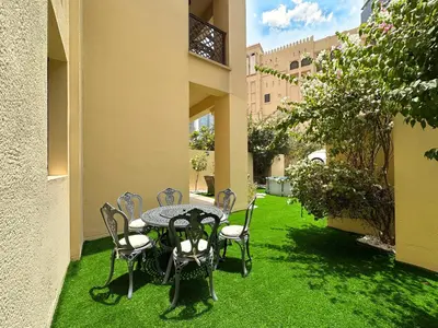 a patio with a table and chairs on the grass at Arabian Nights Luxury Garden Suite in Dubai