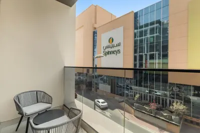 a balcony with a chair in front of a building at Brand New 2BR, Circle Mall View, Great Pool & Gym in Dubai