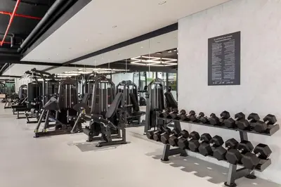 a gym with several rows of tread machines at Brand New 2BR, Circle Mall View, Great Pool & Gym in Dubai
