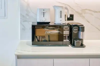 a microwave sitting on top of a counter at PVH - Binghatti Lavender - Tranquil Modern 1BR - Near JVC Community Park in Dubai