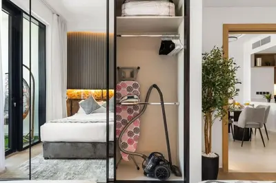 a room with a bed and a desk with a lamp at Stylish 2 Bedrooms, Pool, Gym & Family-Friendly in Dubai