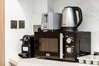 a microwave with a coffee pot on top of it at Stylish Studio in Nad Al Sheba in Dubai