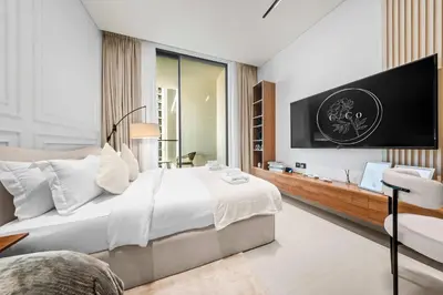 a bedroom with a large bed and a tv at Brand New Luxury Studio, Amazing Pool & Gym in Dubai