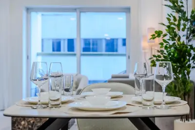 a table with wine glasses and plates on it at TRPS - Elite Residence, Dubai Marina - Modern High-Rise, Near Popular Sites, Partial Sea View in Dubai
