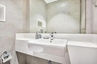 a white bathroom with a sink and a tub at Newly Furnished Apt in District 1 in Dubai