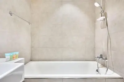 a bathroom with a white tub and a shower at Newly Furnished Apt in District 1 in Dubai