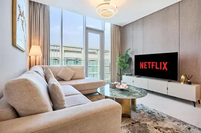 a living room with a couch and a tv at Newly Furnished Apt in District 1 in Dubai