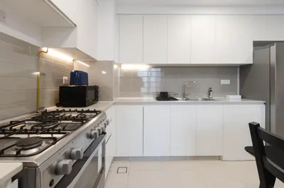 a kitchen with white cabinets and a stove at 2BR in Safi Balcony Walk to Town Sq Park in Dubai