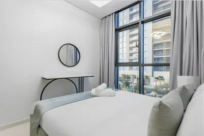 a white bedroom with a bed and a window at Modern Luxury Stylish 2BR Near Downtown in Dubai