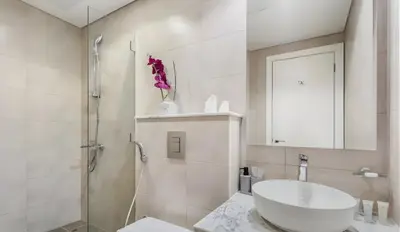 a white bathroom with a sink and a shower at Modern Luxury Stylish 2BR Near Downtown in Dubai