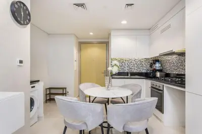 a kitchen with a table and chairs in a kitchen at Modern Luxury Stylish 2BR Near Downtown in Dubai