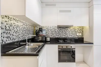 a kitchen with white cabinets and a sink at Modern Luxury Stylish 2BR Near Downtown in Dubai