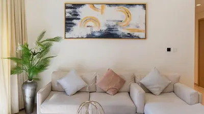 a living room with a white couch with pillows at Luxury 2BR unit with speculator full road view in Dubai