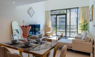a living room with a table and chairs and a living room at Luxury 2BR unit with speculator full road view in Dubai